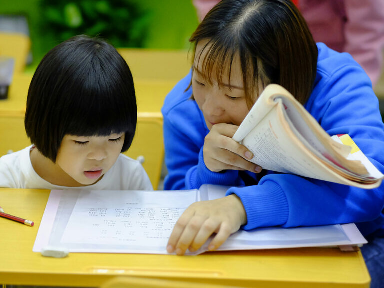 Adult supporting a child during a focused learning activity